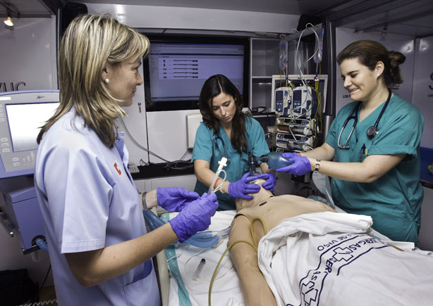 Profesionales sanitarios en formación con un simulador de paciente. 