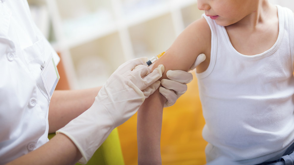 Sanitario vacunando a un niño. 