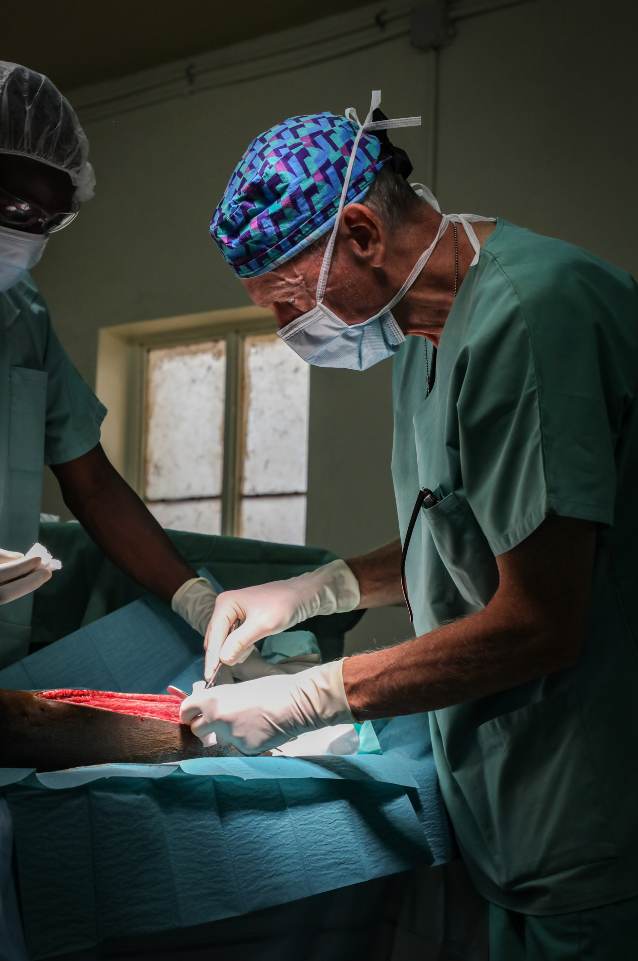 El cirujano David Elliott, de MSF, realiza una fasciotomía en un paciente de 13 años mordido por una serpiente.