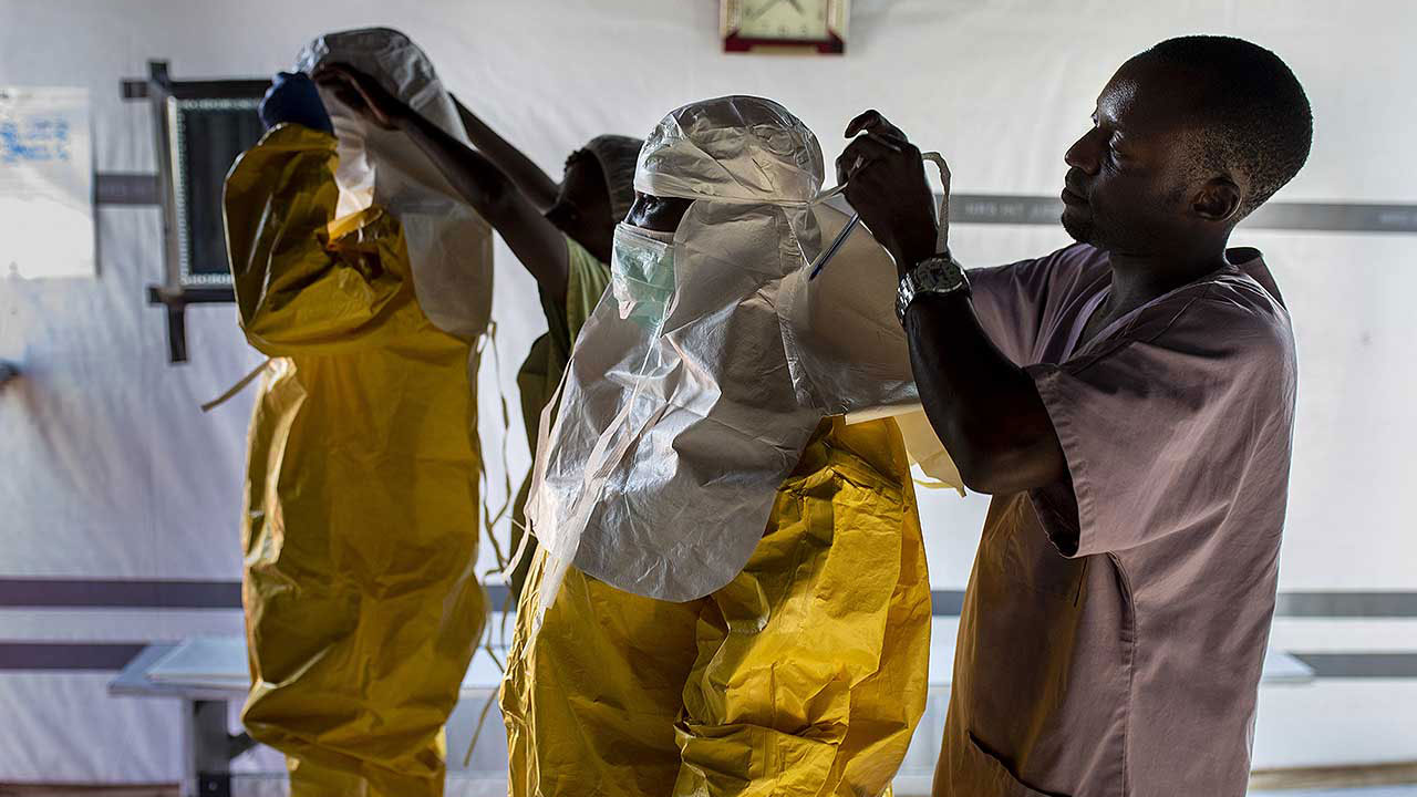 Personal sanitario de Médicos Sin Fronteras se coloca el equipo de protección personal (EPP) frente al Ébola en el Centro de Tránsito de Ébola en Buni, RDC. 
