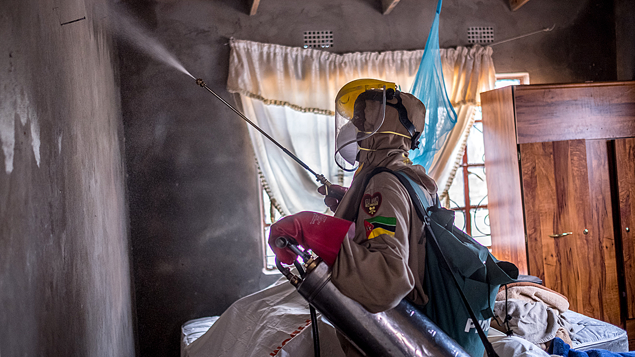 Un trabajador del Centro de InvestigaciÃ³n de Salud de ManhiÃ§a fumiga una casa para eliminar los mosquitos en Timanguene, Mozambique.