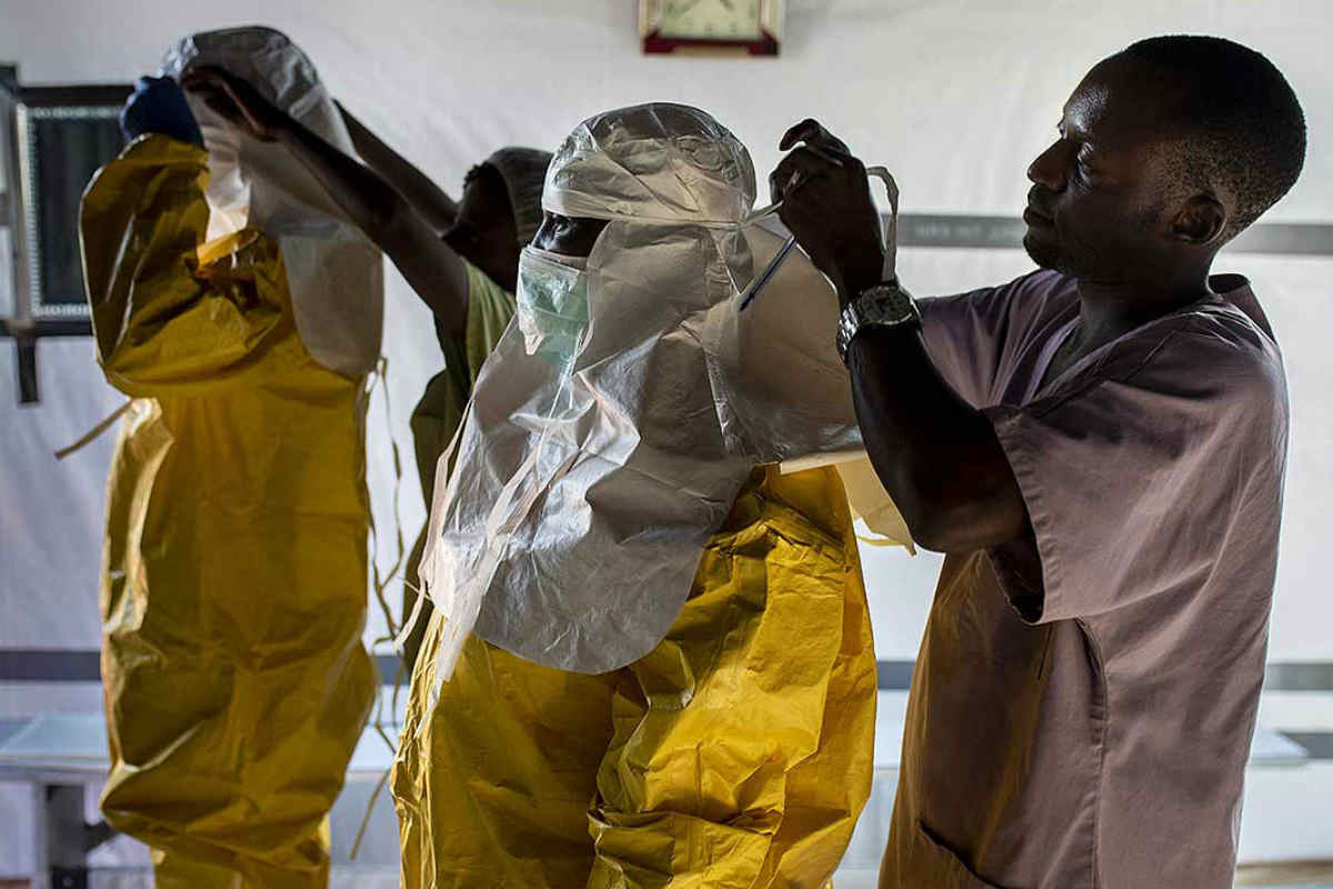 Personal sanitario de Médicos Sin Fronteras se coloca el equipo de protección personal (EPP) frente al Ébola en el Centro de Tránsito de Ébola en Bunia, RDC. 