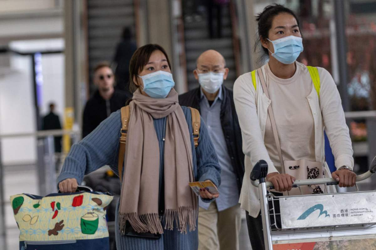 Viajeros con mascarilla para evitar contagios por coronavirus chino, en el aeropuerto Hong Kong. 