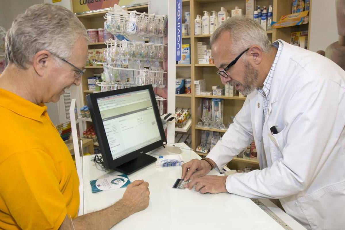 Manuel Ojeda, vicepresidente del COF de Sevilla, atendiendo en su farmacia (ya traspasada), en 2013.