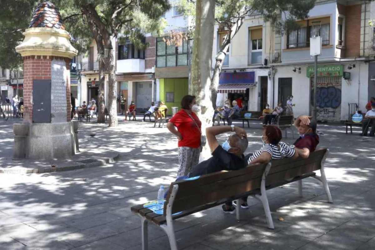 Personas en un banco de una plaza de Hospitalet de Llobregat, en Barcelona. 