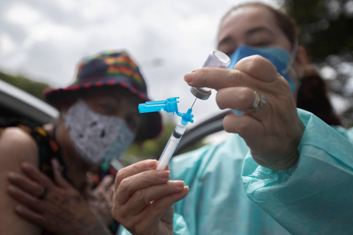 Una mujer prepara una dosis de la vacuna contra covid-19, en Brasilia (FOTO:EFE/Joédson Alves) 
