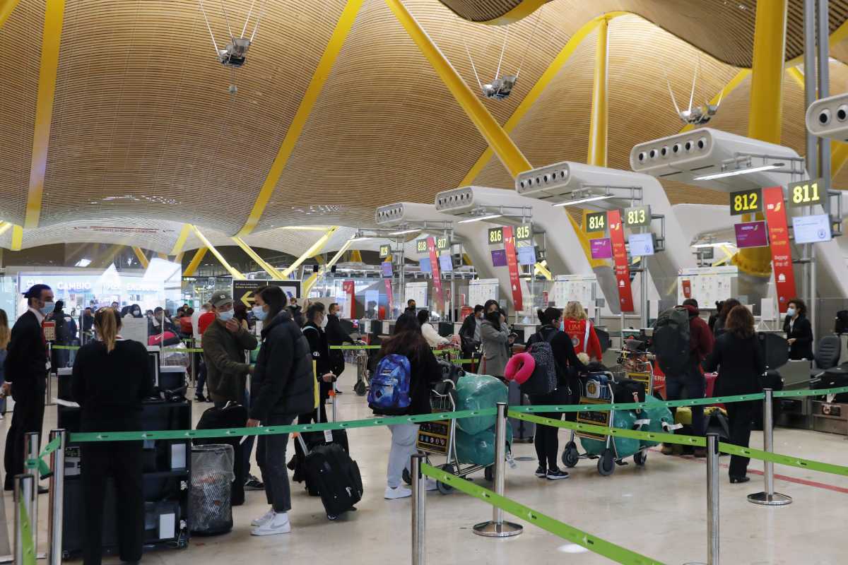 Viajeros guardan cola ante los mostradores de facturación del aeropuerto de Madrid-Barajas. 