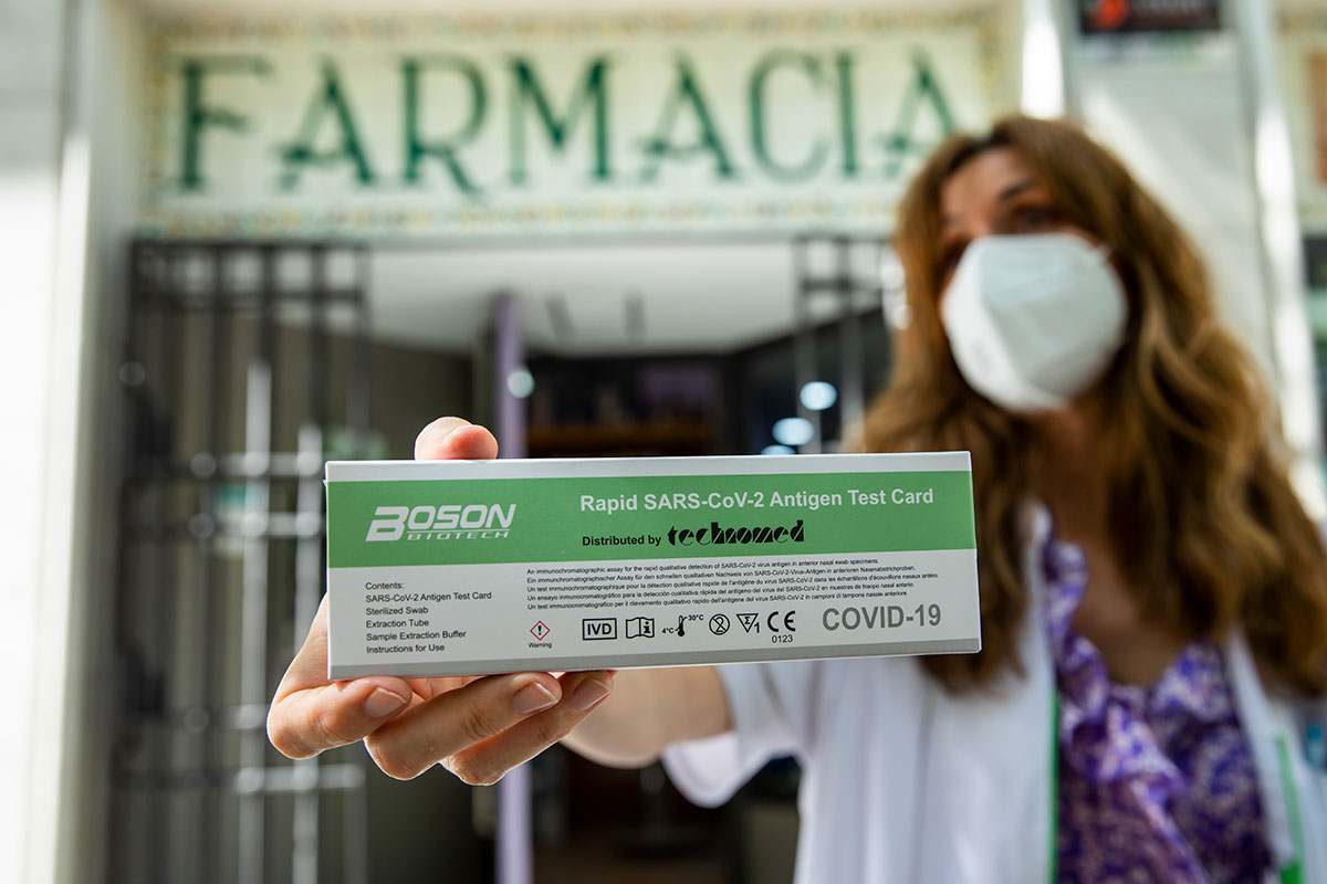 Mª Cruz Sierra, en la puerta de su farmacia de Madrid, mostrando un test de autodiagnóstico. /Bernardo Díaz.