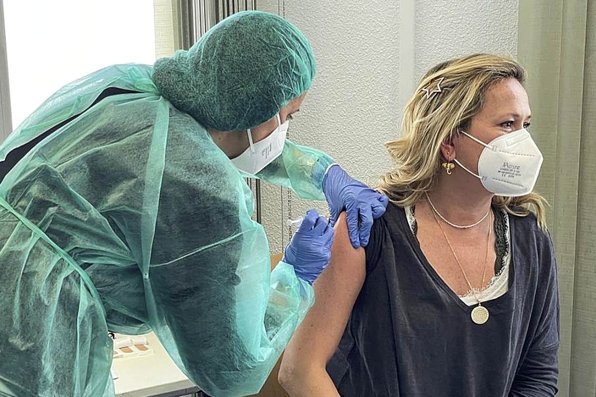 Una farmacéutica vacunando a una compañera en el COF de Madrid. 