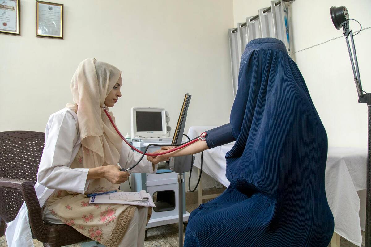 Saleema Rehman, mÃ©dico refugiada afgana, atiende a otra refugiada en su clÃnica privada de Attock (PakistÃ¡n). /Acnur.