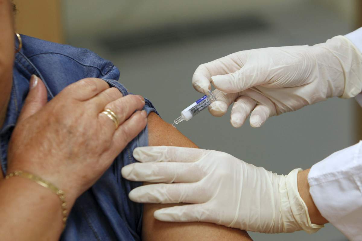 Una enfermera pone una vacuna contra la gripe en un ambulatorio de Madrid en la campaña de 2020. / EFE (Javier Lizón). 