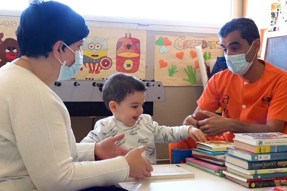 El cirujano maxilofacial Santiago Ochandiano con uno de los pacientes tratados y su madre.