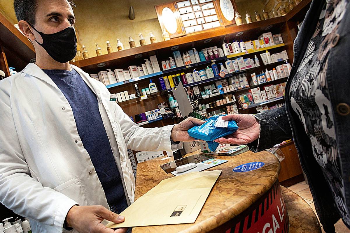 Óscar Capel, farmacéutico comunitario de Barcelona, entrega su medicación hospitalaria a un paciente. /Jaume Cosialls.