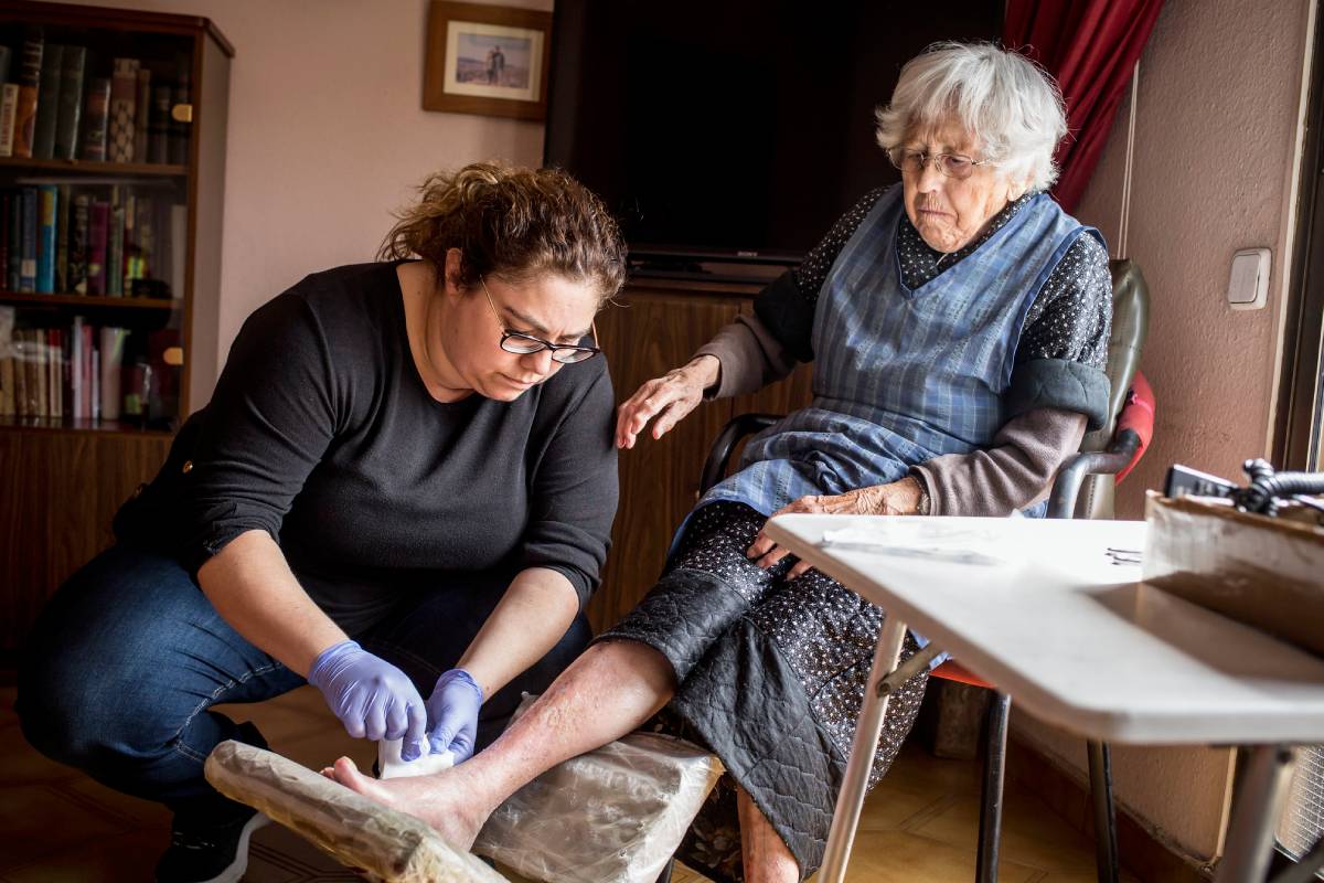 Una enfermera realiza una cura en un domicilio (Foto: Banc de Imatges Infermeres / Ariadna Creus i Àngel García)