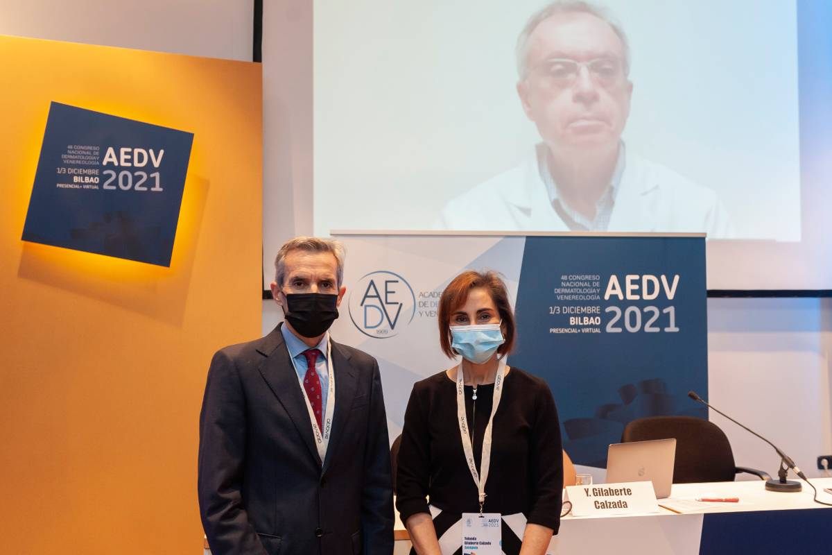 Jesús Gardeazábal, presidente de la sección Vasco-Navarro—Aragonesa-Riojana de la AEDV; Yolanda Gilaberte, vicepresidenta primera de la AEDV, y, en pantalla, Jorge Soto, director de la Fundación Piel Sana.