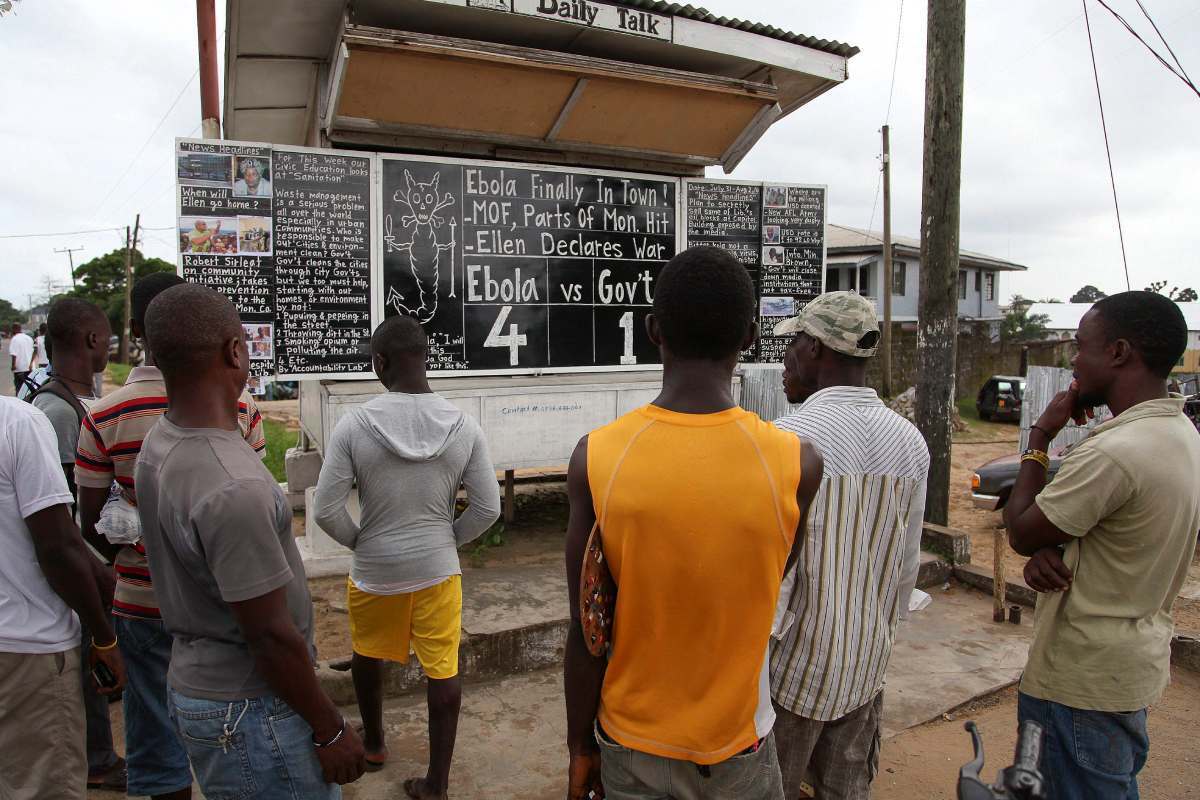 Un grupo de personas observa el tablero con las cifras de víctimas mortales de Ébola en el brote en África Occidental de 2014 (FOTO: EFE). 