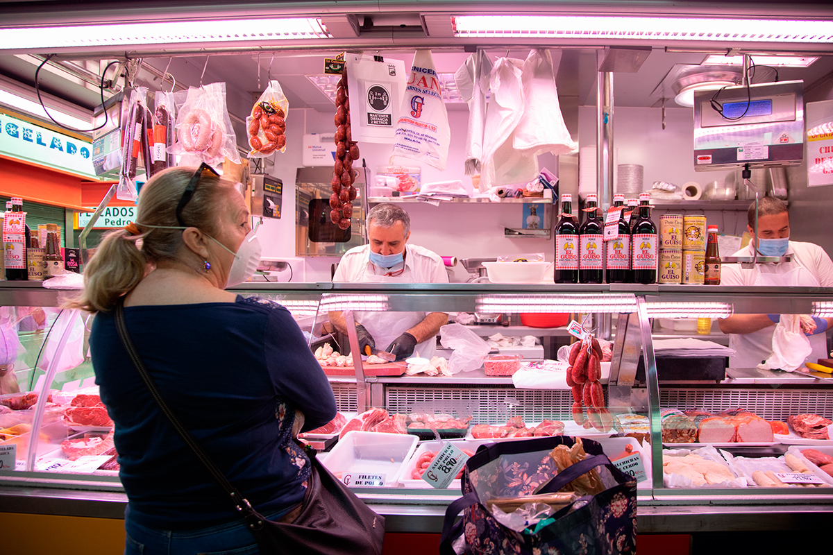 Una mujer realizando la compra en el mercado de Málaga