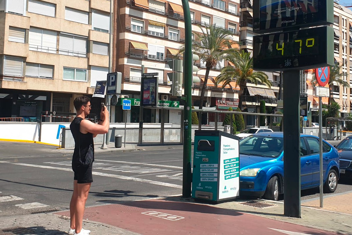 Un joven fotografía un termómetro de calle que marca 47 grados en el centro de Córdoba durante la primera ola de calor, a finales de junio. Foto: OLGA LABRADOR / EFE 