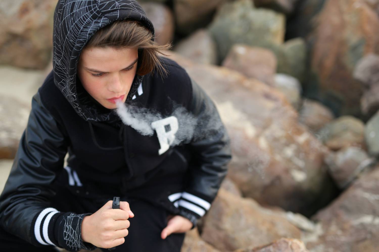 Un adolescente fumando un cigarro electrónico. 