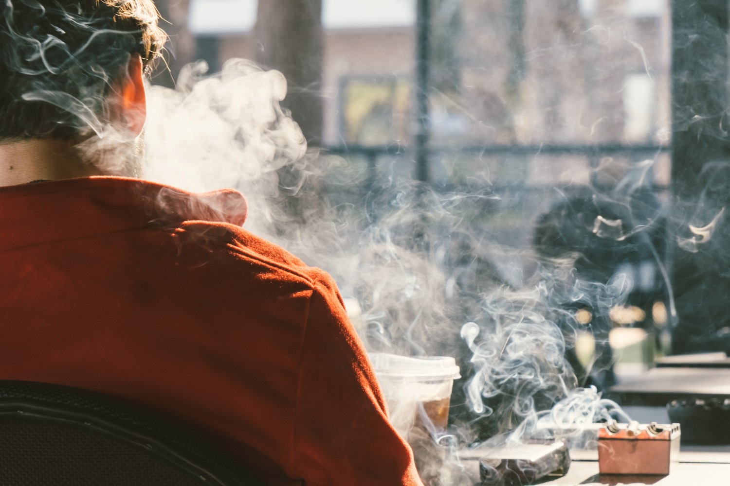 Un hombre fumando en una cafetería. Foto: SHUTTERSTOCK.