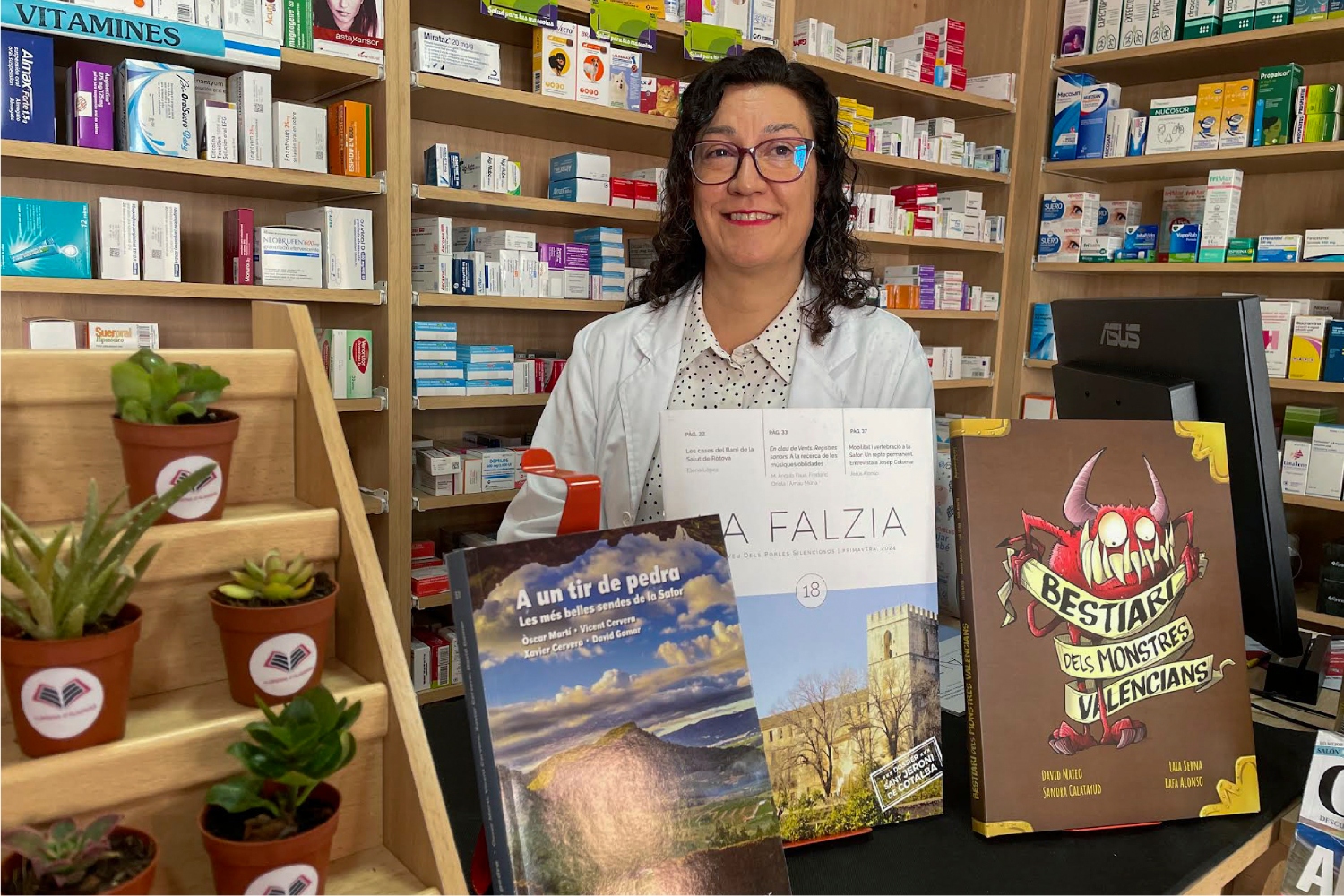 Matilde Soler en su farmacia de Almiserà (Valencia), mostrando algunos de los más de 2.000 libros que vende en su botica. Foto: EFE/ RAQUEL SEGURA. 