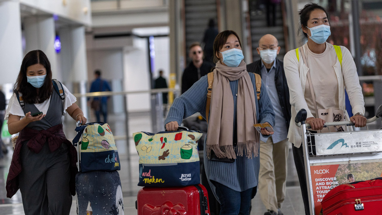 Viajeros con mascarilla para evitar contagios por coronavirus chino, en el aeropuerto Hong Kong.