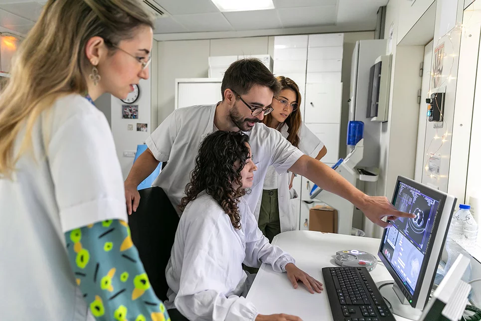 MIR del servicio de Radiodiagnóstico del Hospital Clínic de Barcelona observan a una técnico de imagen mientras realiza un TC de tórax. Fotos: SONIA TRONCOSO.