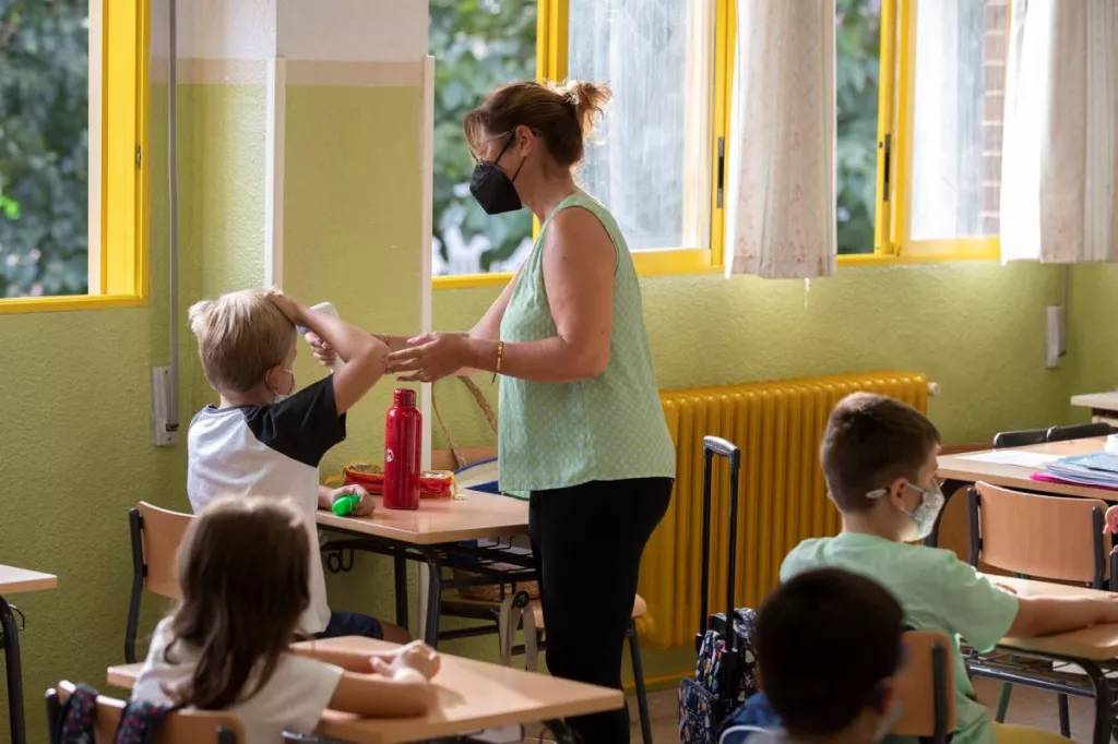 Una profesora le toma la temperatura a un niño. Foto: EFE/MARCIAL GUILLÉN