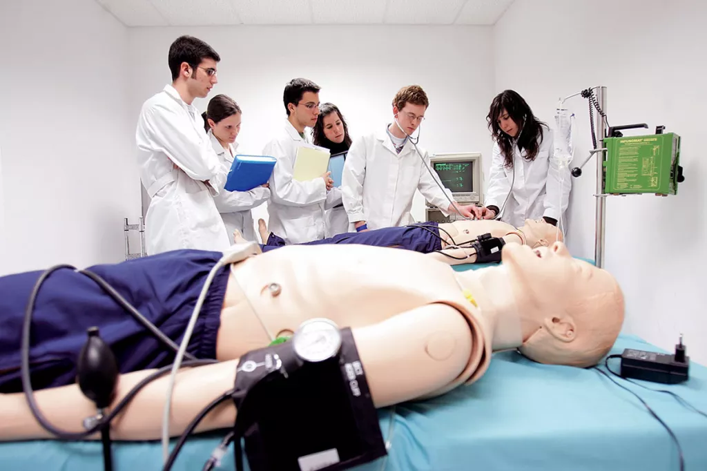 Un grupo de estudiantes comprueba las constantes vitales de un maniqu.