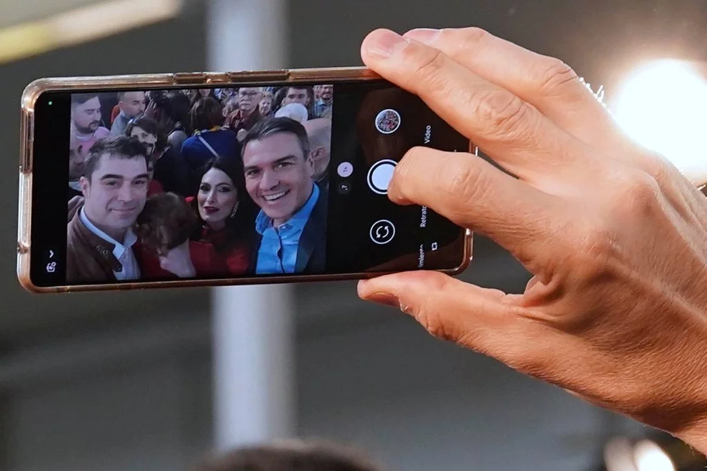 Detalle de la mano del presidente del Gobierno, Pedro Sánchez, haciéndose una foto con los asistentes al mitin electoral de Valladolid. Foto: EFE/NACHO GALLEGO.