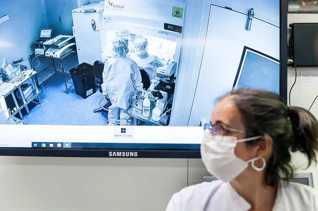 La sala blanca del ClÃnic donde se producen los CAR-T vista en una pantalla en el exterior del laboratorio.