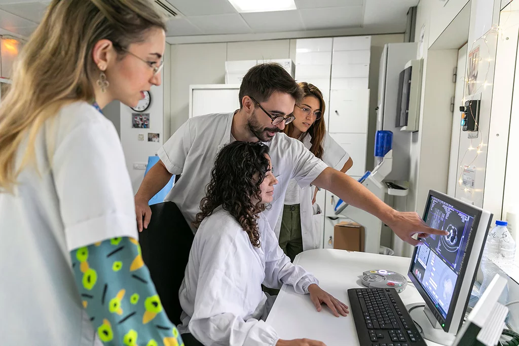 MIR del servicio de Radiodiagnóstico del Hospital Cl�nic de Barcelona observan a una técnico de imagen mientras realiza un TC de tórax. Fotos: SONIA TRONCOSO.
