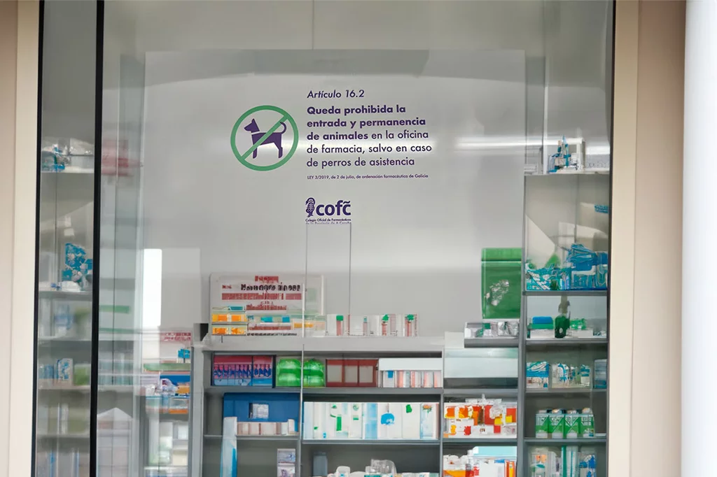 Las farmacias gallegas están recordando con carteles que desde 2019 está prohibido el acceso con animales en las boticas.