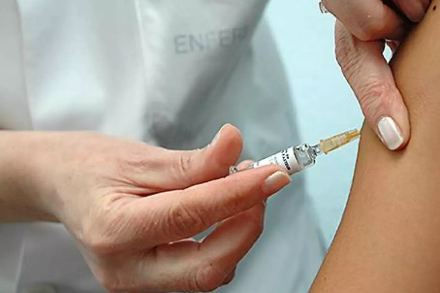 Una enfermera poniendo una vacuna.