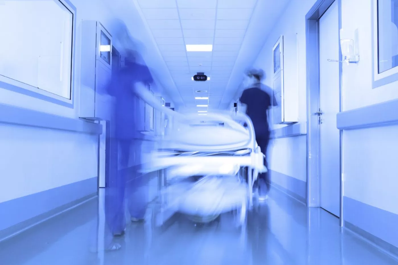 Una camilla avanza por el pasillo de un hospital.