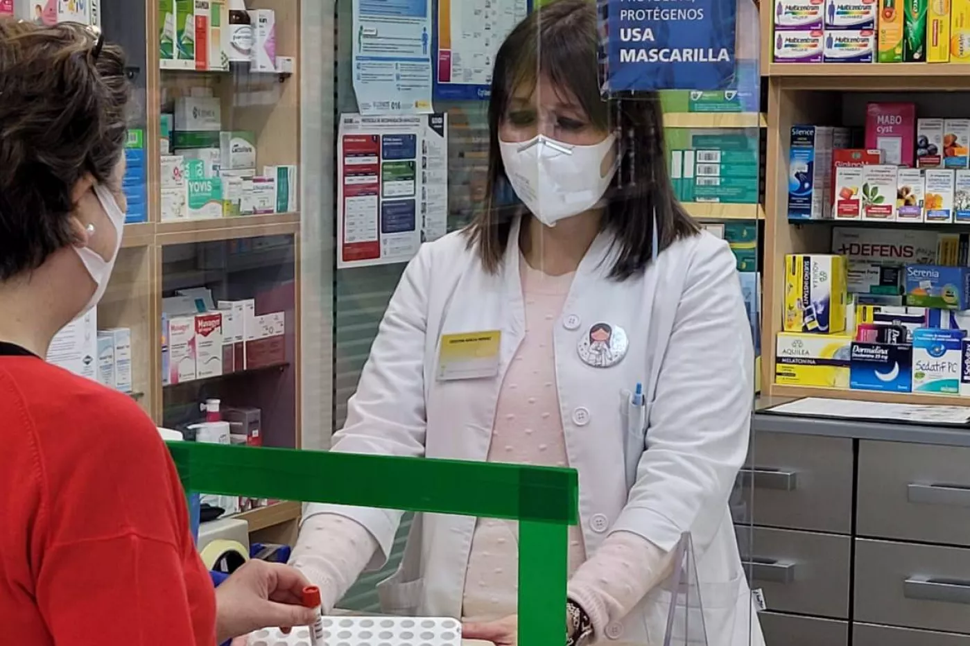 Una usuaria depositando una automuestra de saliva en una farmacia de Agolada (Pontevedra).