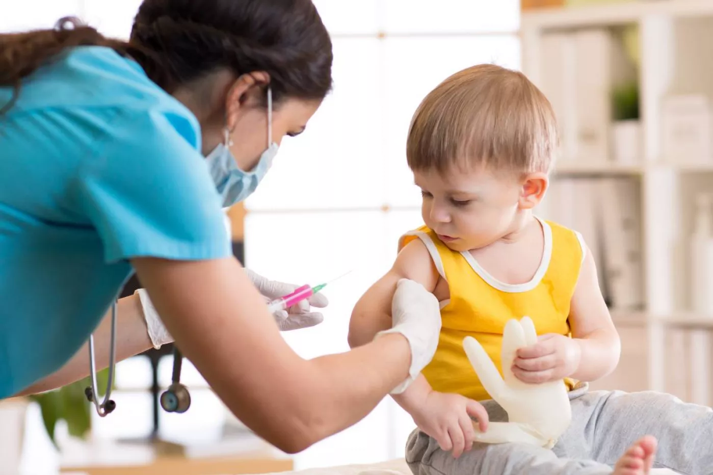 Enfermera vacunando a un niño pequeño