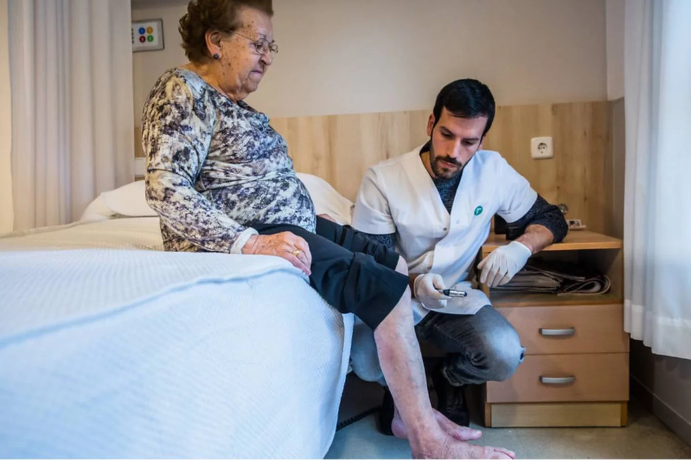 un enfermero explora los reflejos en un caso de pie diabético. FOTO: Ariadna Creus y Ángel García (Banc Imatges Infermeres).