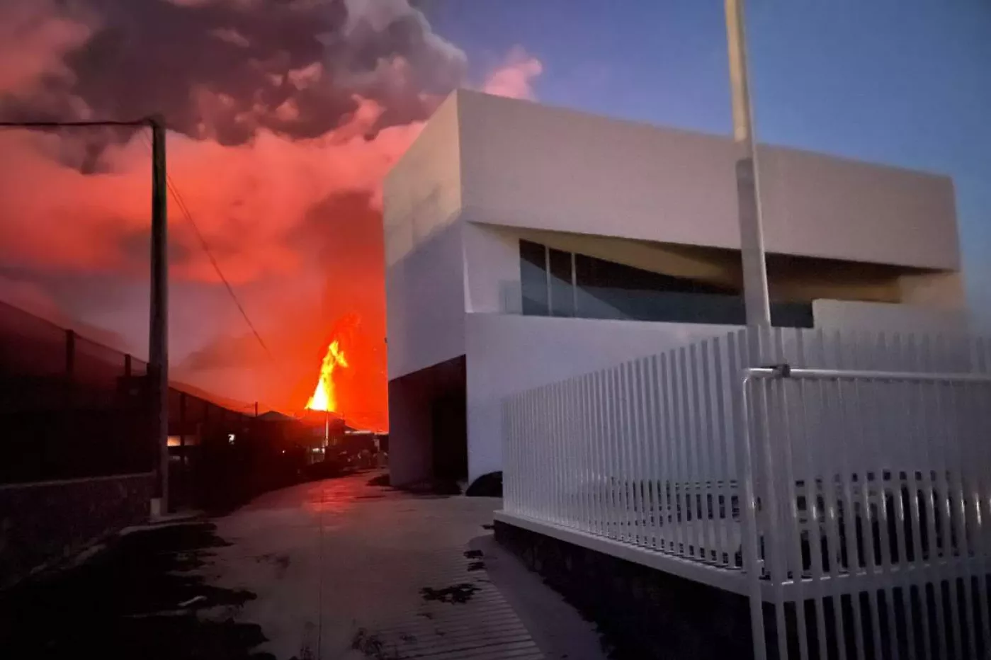 El nuevo almacén de Cofarte en La Palma, con el volcán erupcionando al fondo.