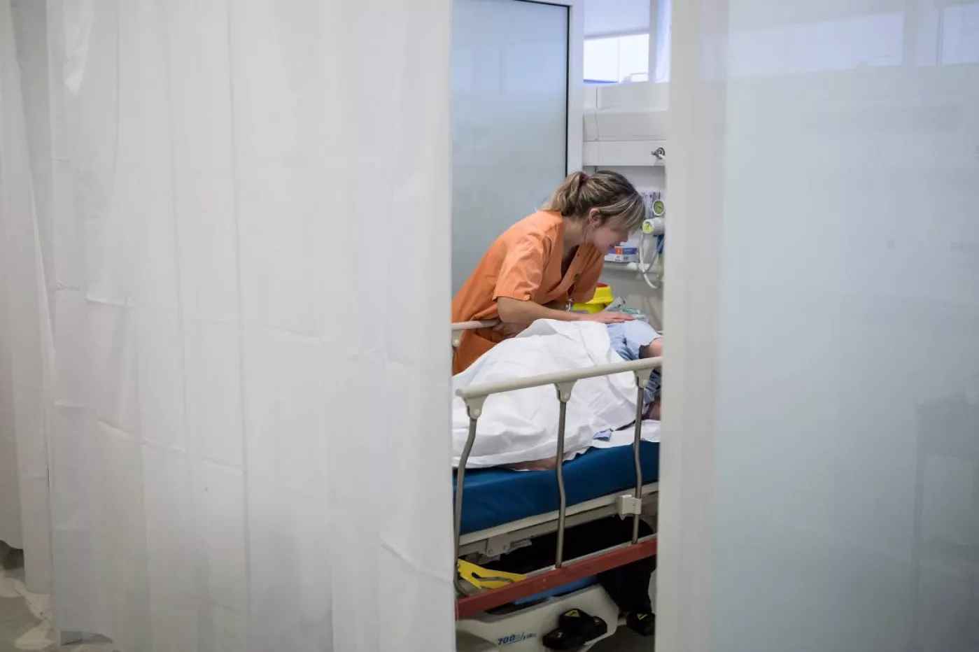 Una enfermera tendiendo a un paciente. FOTO: Ariadna Creus y Àngel García (Banc Imatges Infermeres).