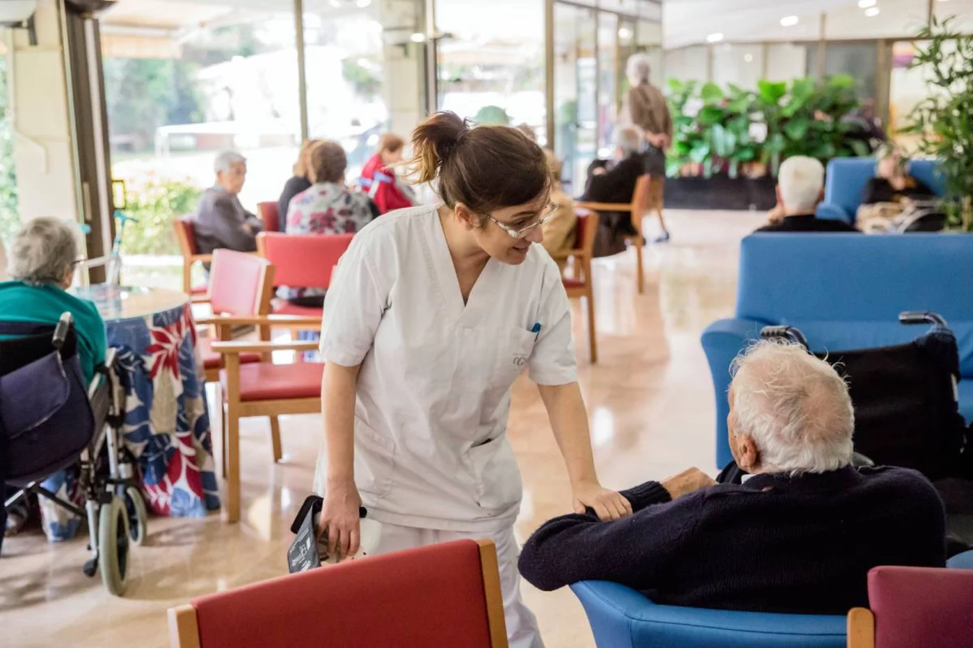 Una enfermera conversa con un anciano en una residencia de mayores. Foto. ARIADNA CREUS y ÀNGEL GARCÍA (BANC IMATGES INFERMERES).