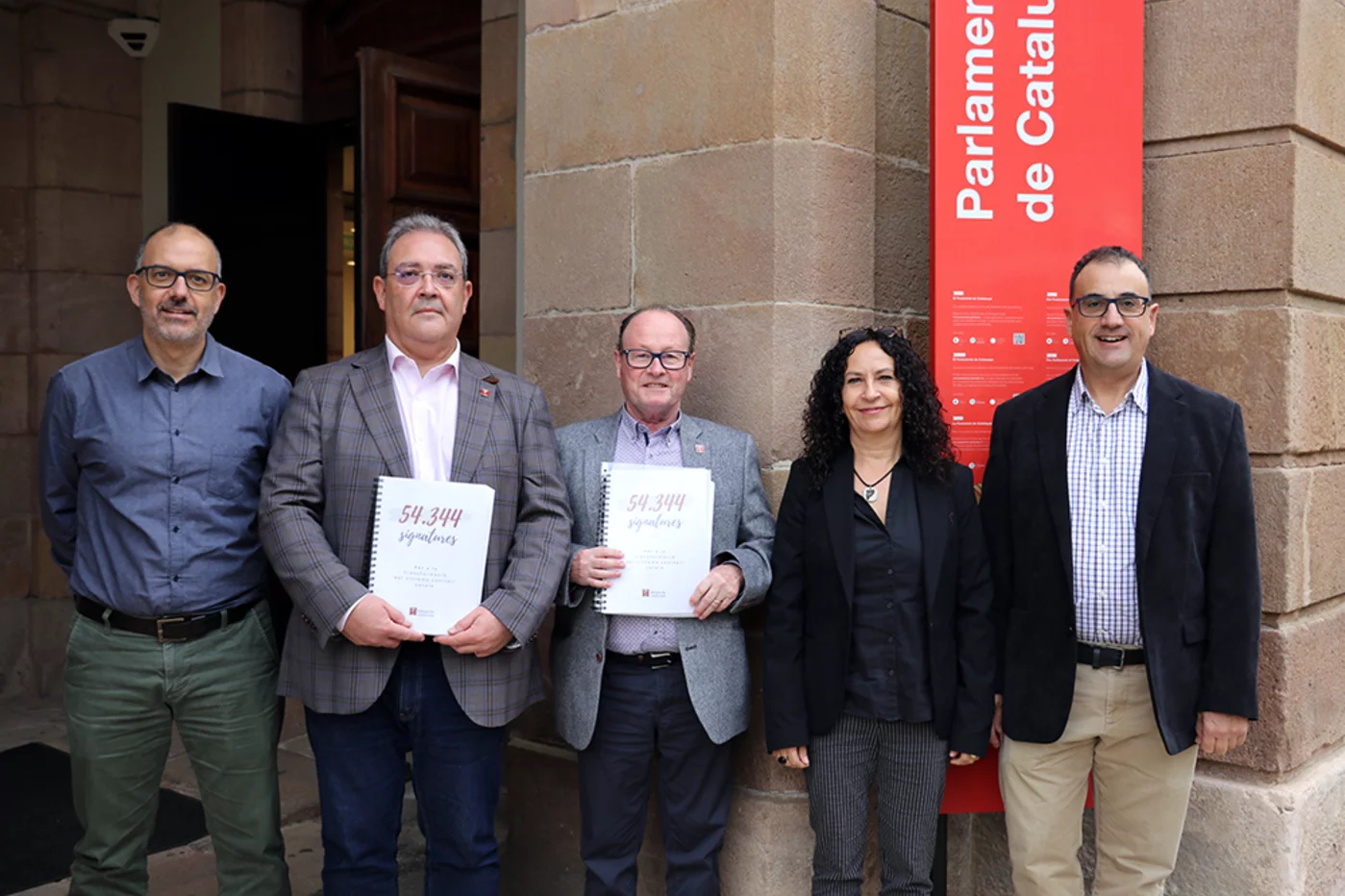 La dirección del sindicato Médicos de Cataluña muestra las 54.344 firmas recogidas entre la cieudadanía antes de entrar en el Parlamento autonómico. Foto: METGES DE CATALUNYA