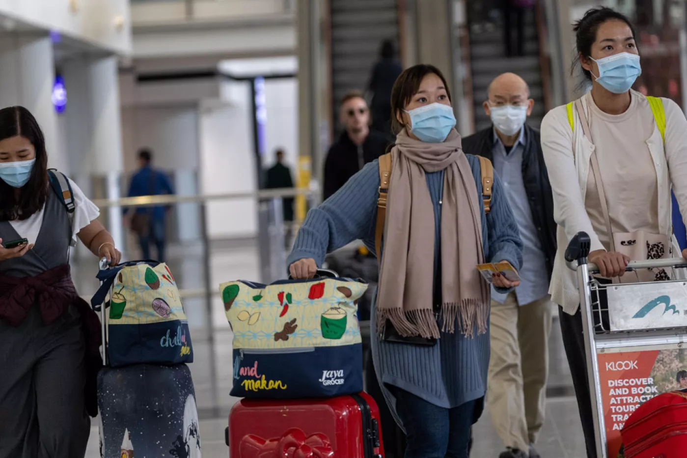 Viajeros con mascarilla para evitar contagios por coronavirus chino, en el aeropuerto Hong Kong.