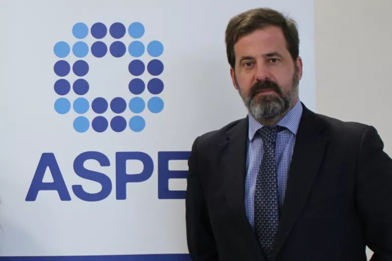 Carlos Rus, presidente de ASPE, delante del logotipo de la entidad