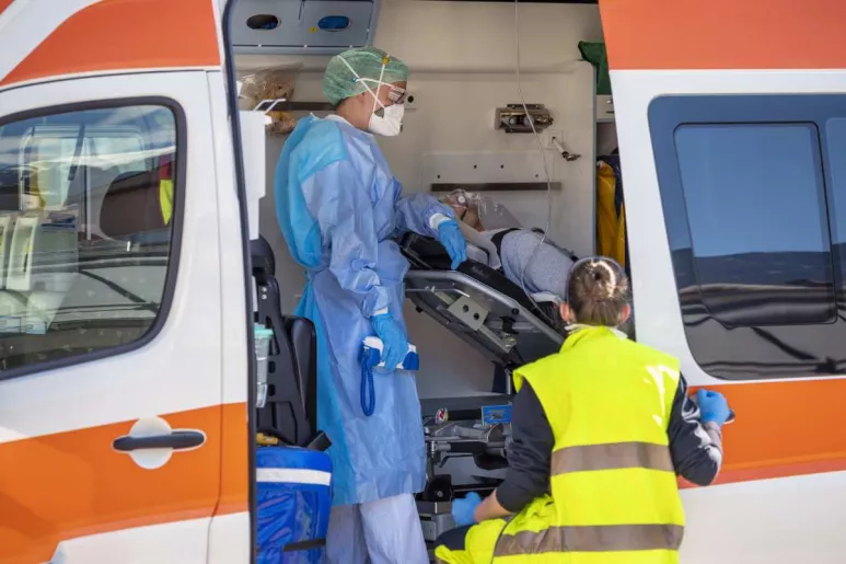 Personal sanitario atendiendo a un paciente en el interior de una ambulancia.