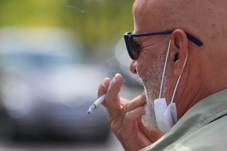 Un hombre fumando tras bajarse la mascarilla. (EFE/Fernando Alvarado)