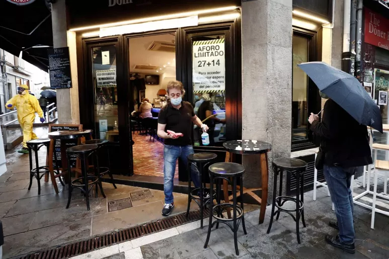 Un camarero se dispone a desinfectar el mobiliario del bar en Navarra.