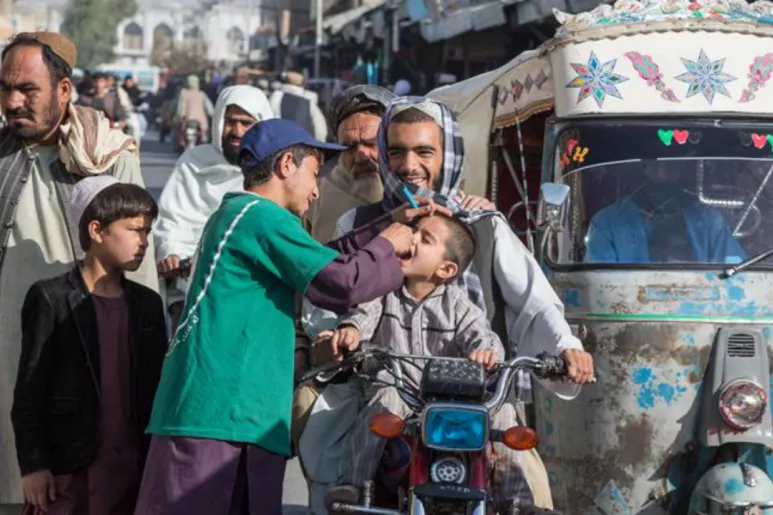 Abdhul Rahman, voluntario de vacunación contra la poliomielitis, administra la vacuna oral a un niño afgano.