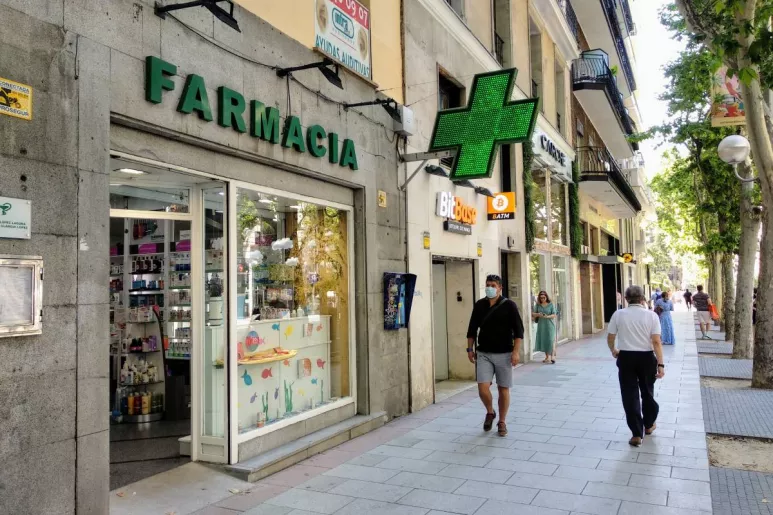 Peatones junto a una farmacia en el centro de Madrid (FOTO: C. Torrente).