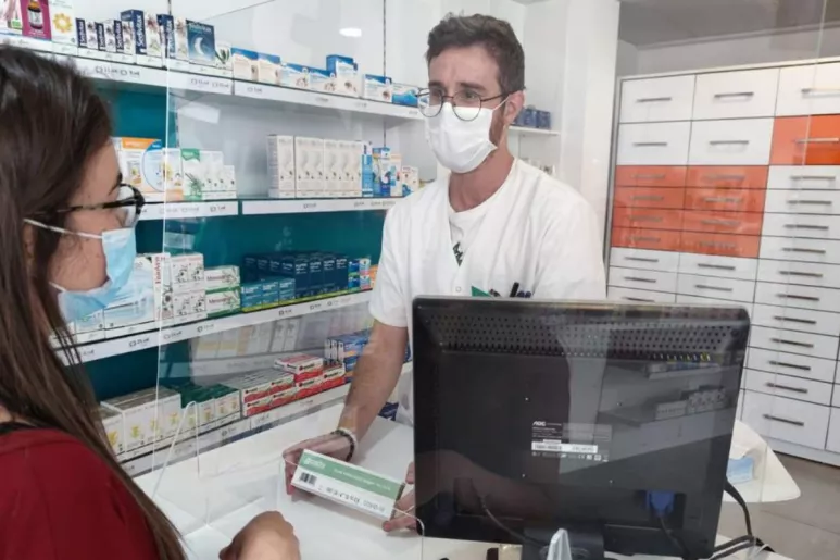 Un farmacéutico de la Región de Murcia dispensando un test de autodiagnóstico covid.